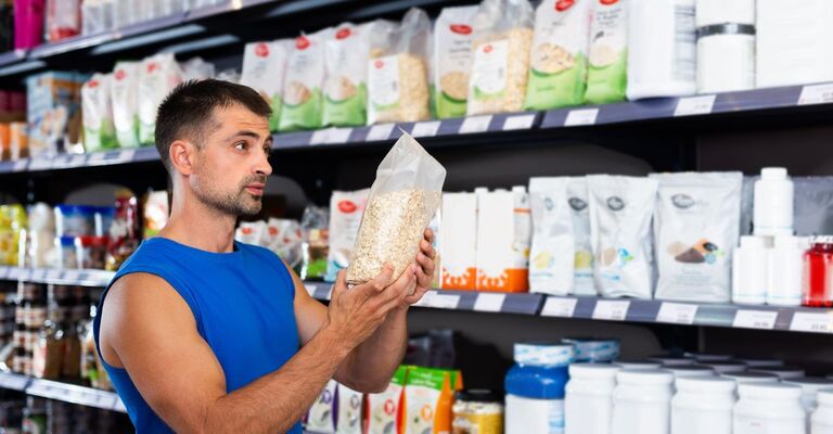 un ragazzo guarda l'etichetta di un prodotto al supermercato