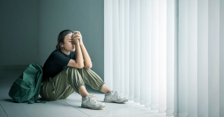 Ragazza in crisi seduta per terra