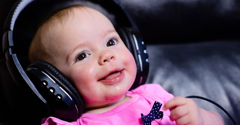 Neonata con cuffie grandi in testa