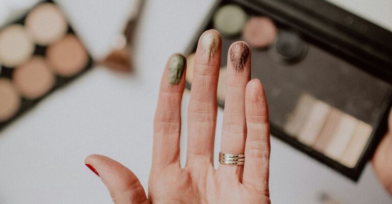 Mano con swatches degli ombretti per occhi