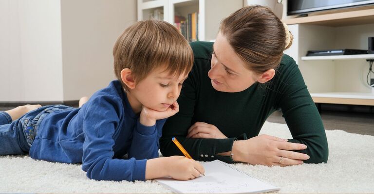 bimbo parla con la mamma, sdraiato sul tappeto