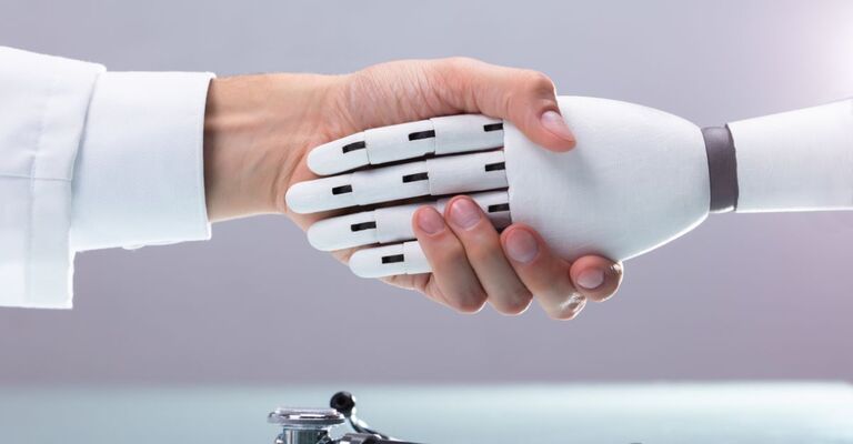 Mano umana stringe una mano cybernetica