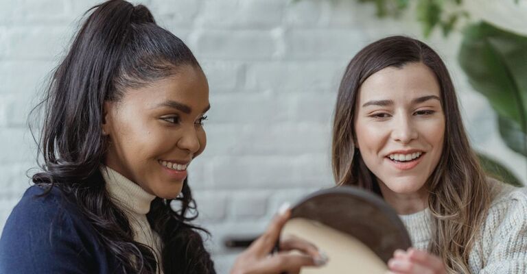 Due donne davanti a uno specchio durante una consulenza di immagine