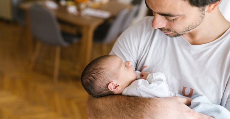 un papà canta cerca di far addormentare il proprio figlio