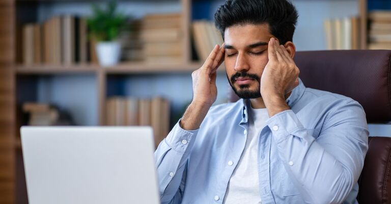 uomo si massaggia le tempie