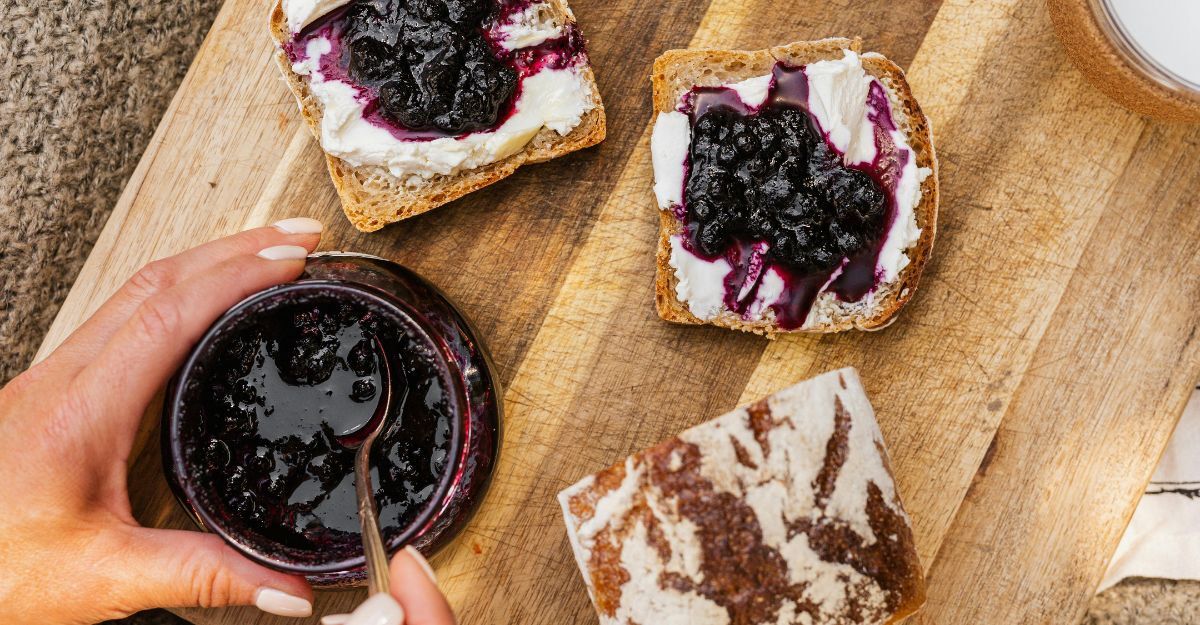 Fette di marmellata con mano che si prepara a spalmarle