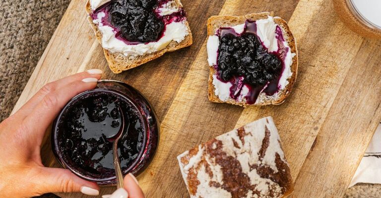 Fette di marmellata con mano che si prepara a spalmarle