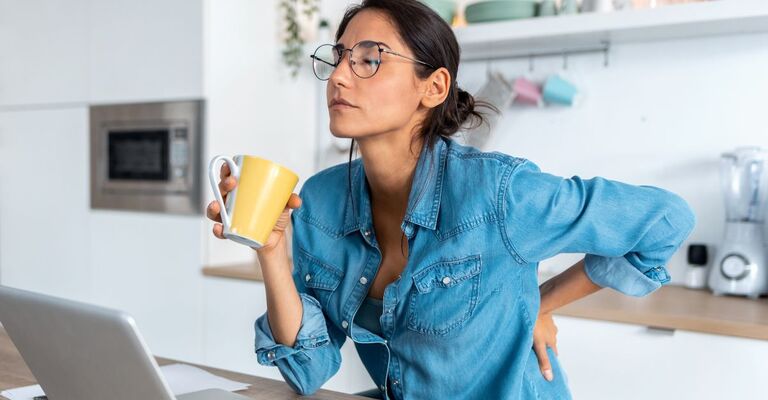ragazza con dolore alla schiena mentre lavora al pc