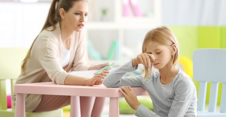 Una bambina parla con uno psicoterapeuta