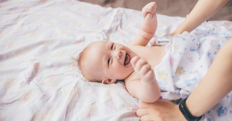 Un neonato ride mentre è sdraiato