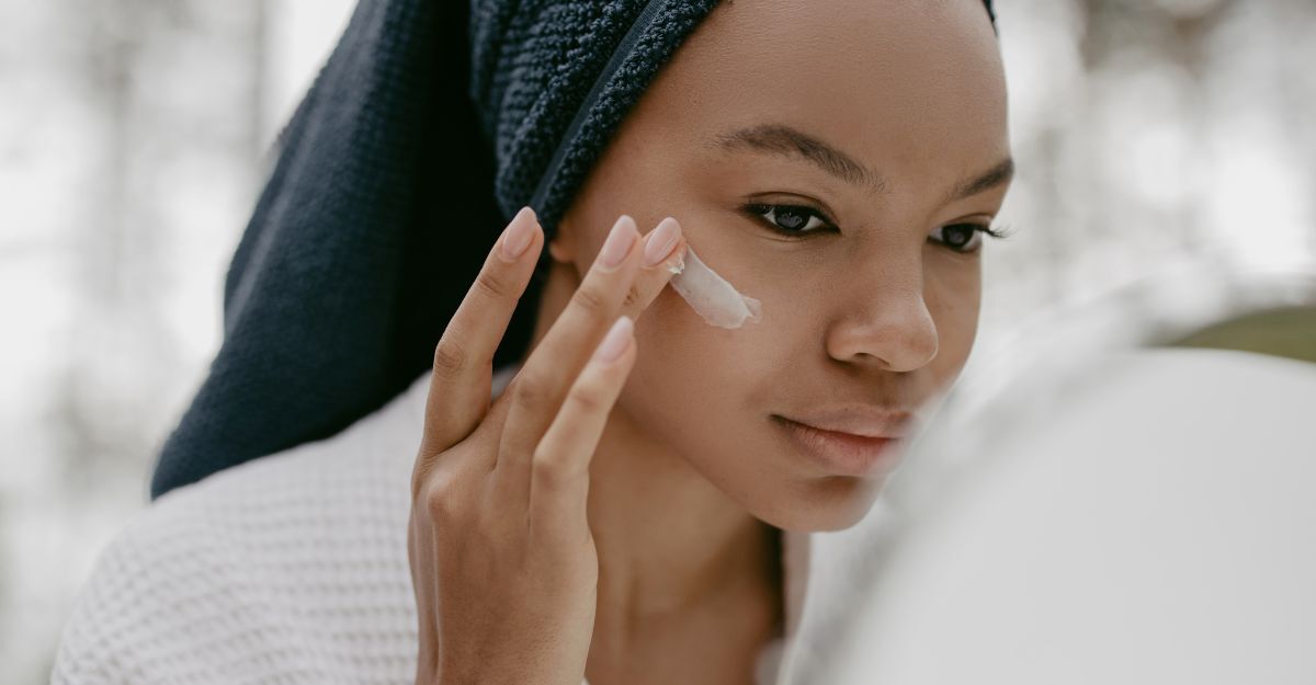 Una donna che si mette la crema