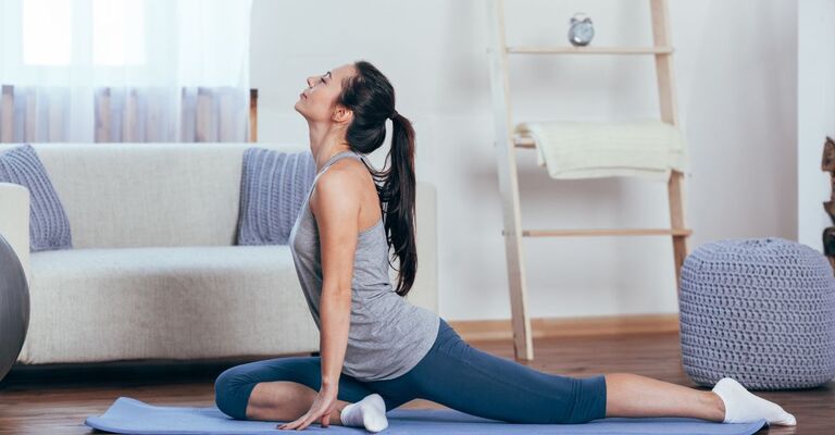 ragazza fa yoga in salotto