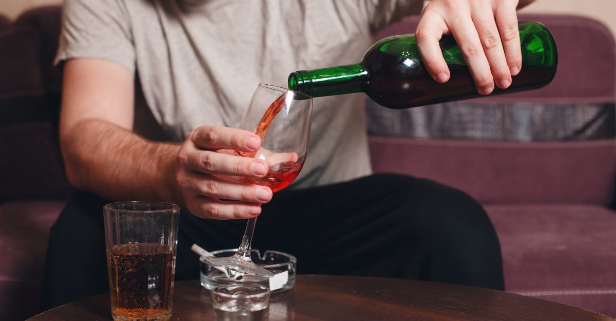 Un uomo affranto si versa un bicchiere di vino