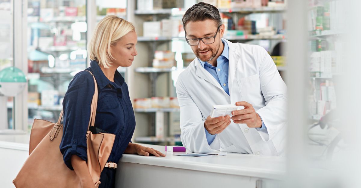 Cliente al bancone parla col farmacista dell'acquisto di un farmaco