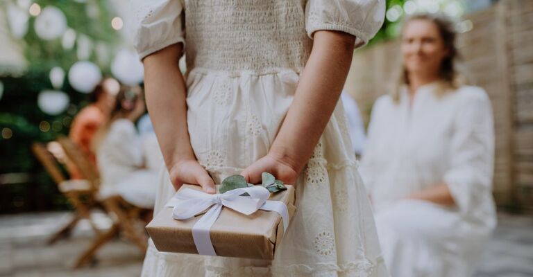 Bambina tiene dietro la schiena il regalo per la sposa