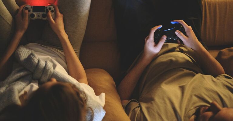 Un ragazzo e una ragazza giocano ai videogiochi sul divano