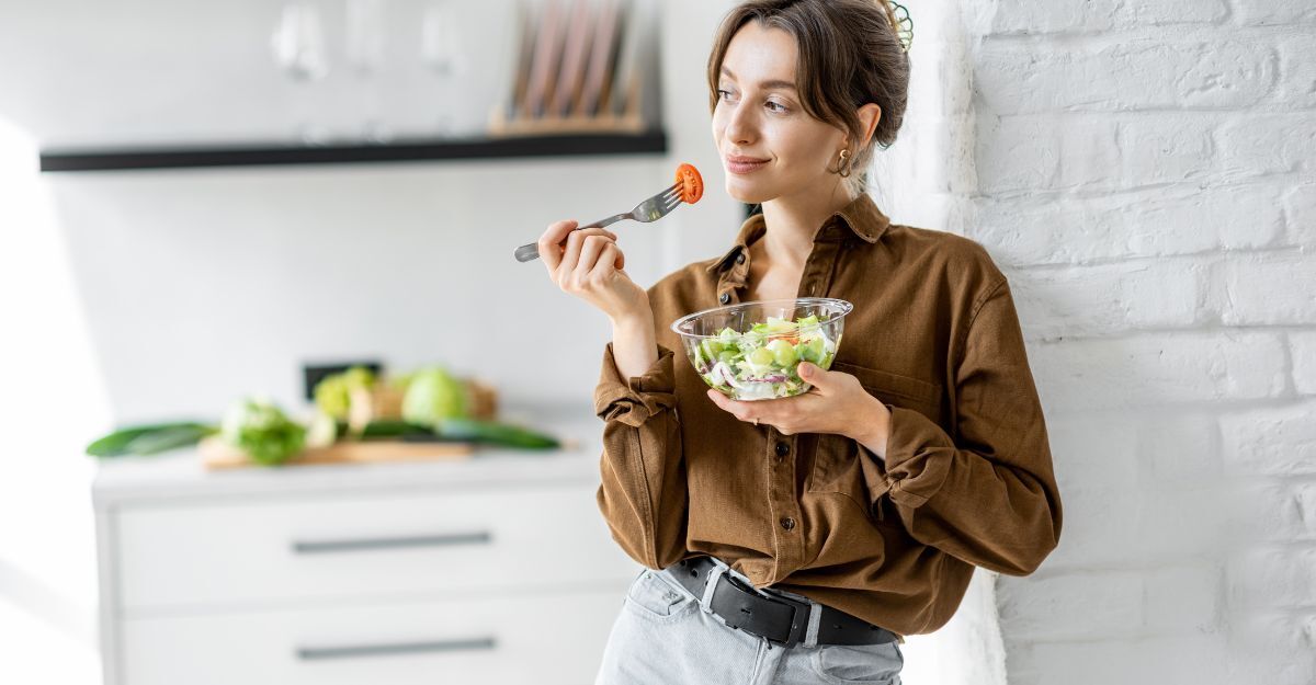 ragazza mangia insalata in piedi