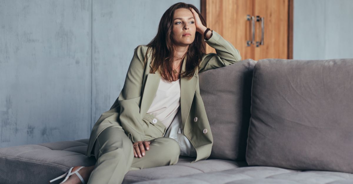 Donna seduta su un divanetto pensierosa