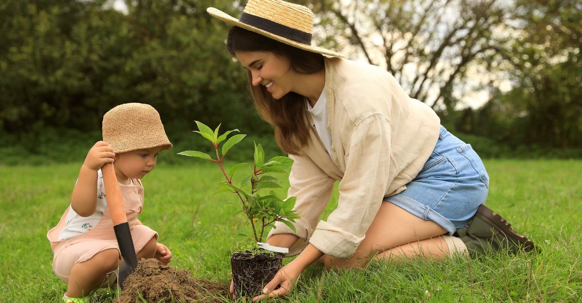 mamma e figlia piantano albero in giardino