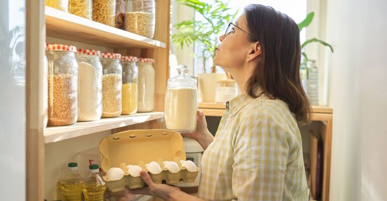 Una donna osserva la sua dispensa