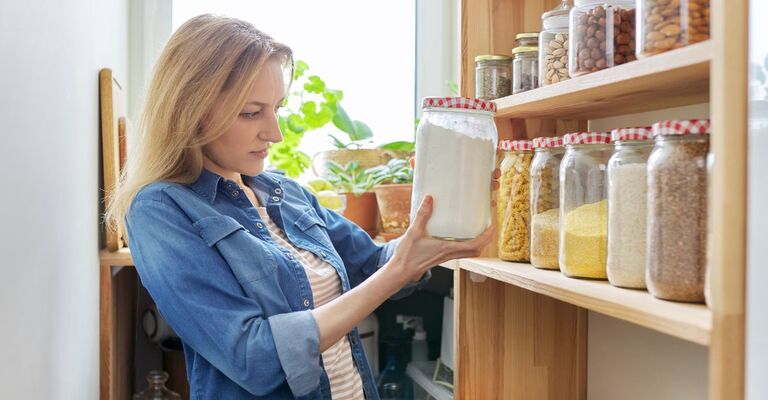 ragazza controlla gli scaffali in cucina