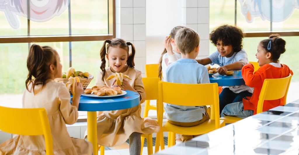 Dei bambini che fanno merenda ad un tavolo