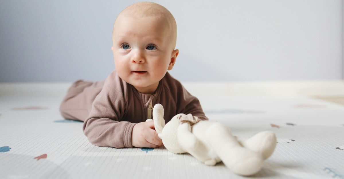 Neonato gioca con un peluche