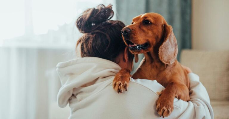 Padrona col cane in braccio sulla spalla