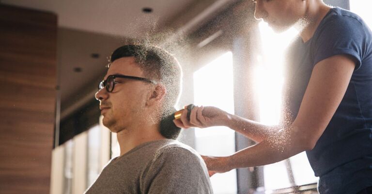 Un barbiere mette il borotalco sui capelli di un cliente
