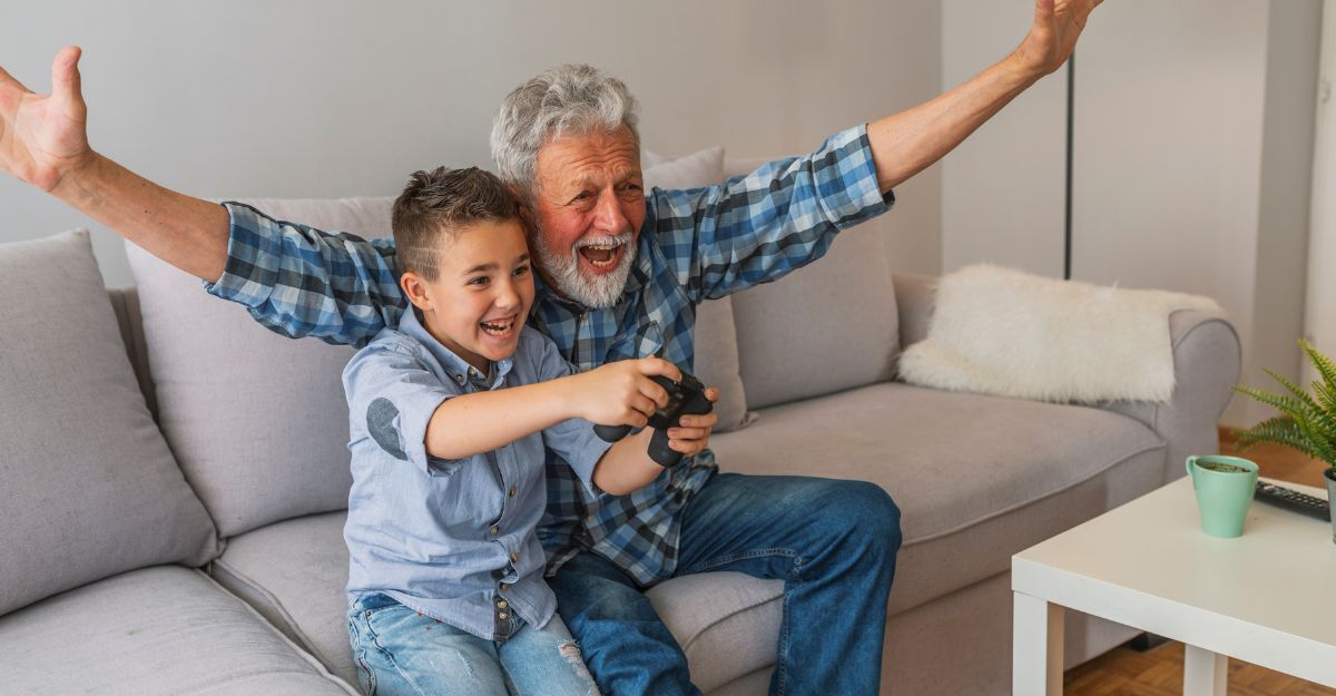 nonno e nipote giocano ai videogiochi sul divano