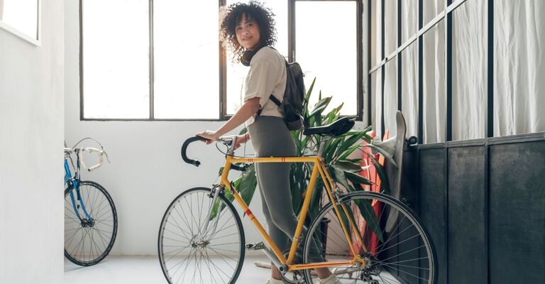 Donna che porta la bici sorridendo