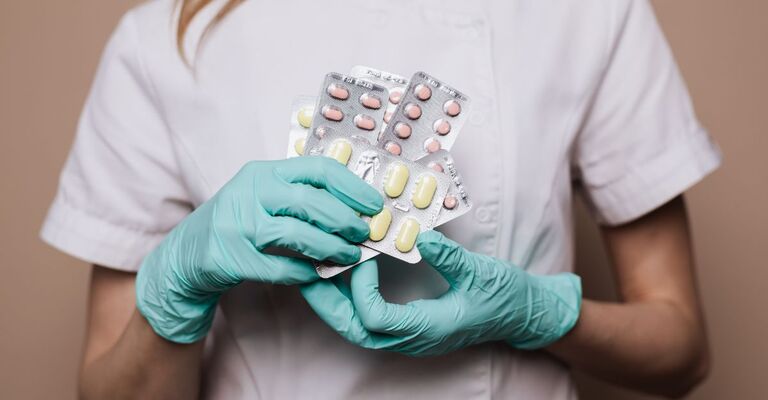 Operatrice sanitaria ha in mano dei famaci indossando dei guanti