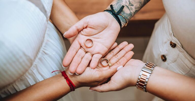 Due mani con le fedi, una sopra l'altra