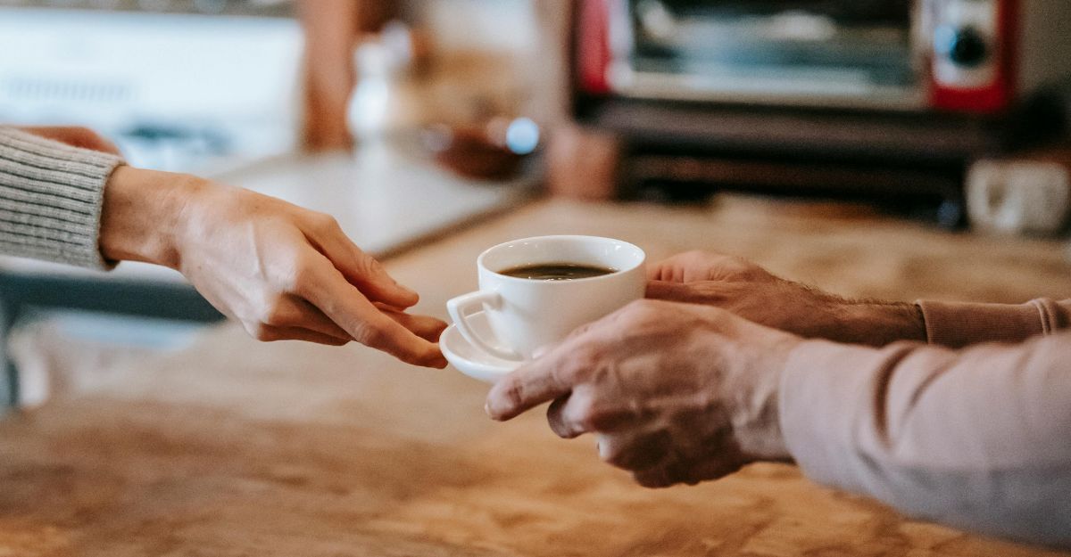 Una mano passa un caffé a un'altra persona