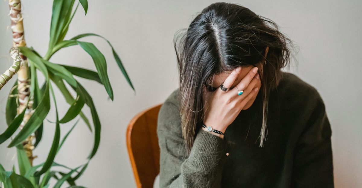 Ragazza sembra giù di morale, è seduta e si tiene il viso con una mano sulla fronte