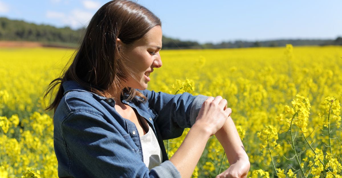 Donna si gratta il braccio in un campo
