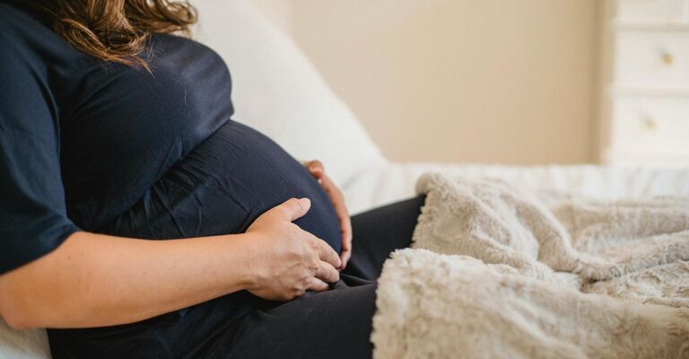 Donna sdraiata che si tiene la pancia