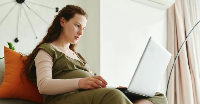 Donna incinta che usa il PC