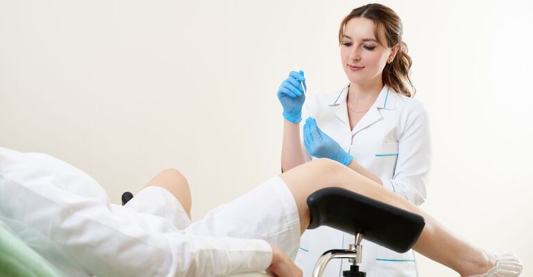 Ginecologa effettua pap test su paziente sul lettino