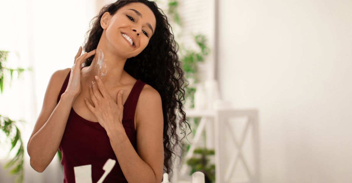 ragazza si spalma crema sul collo