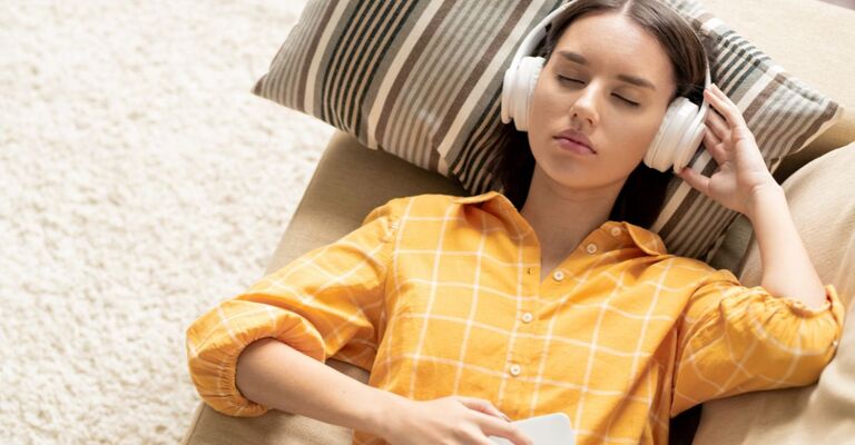 Ragazza rilassata sul divano con cuffie