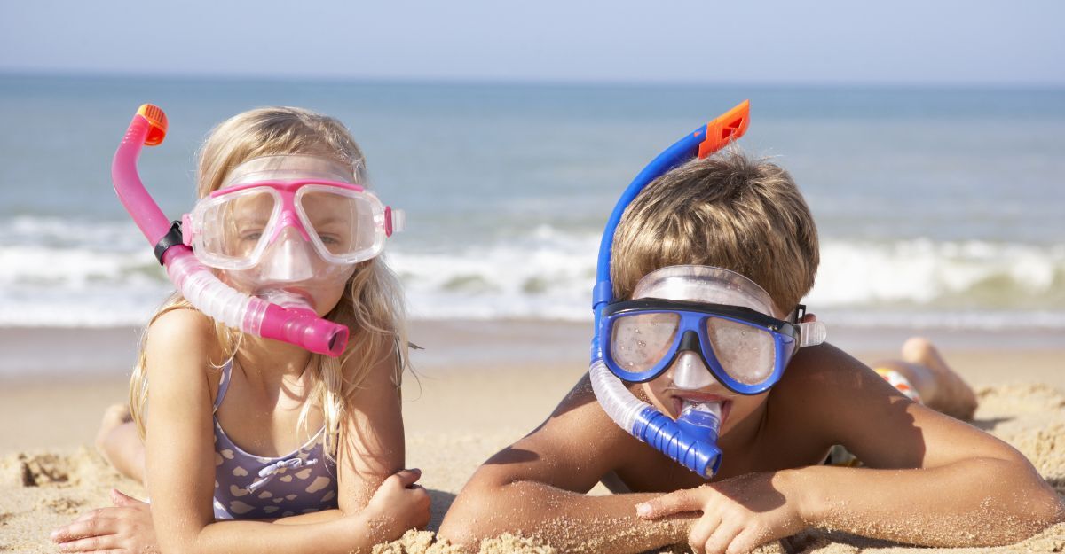 Due bambini in spiaggia con boccaglio
