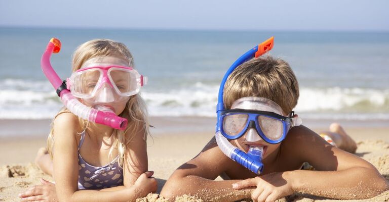 Due bambini in spiaggia con boccaglio