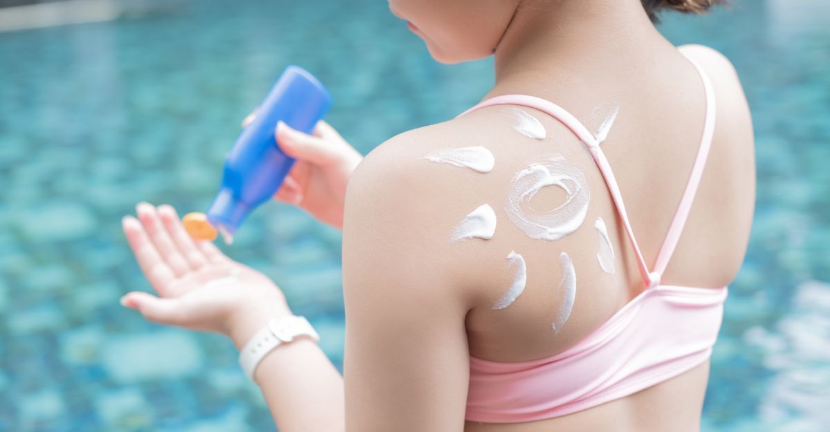 ragazza con la pelle chiara si mette la crema solare