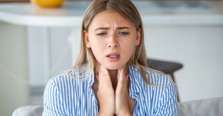 Una donna con dolore alle tonsille
