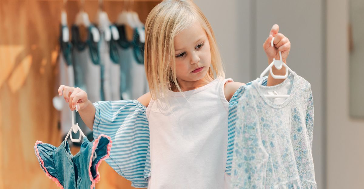 Bambina con stampelle con vestiti che sceglie