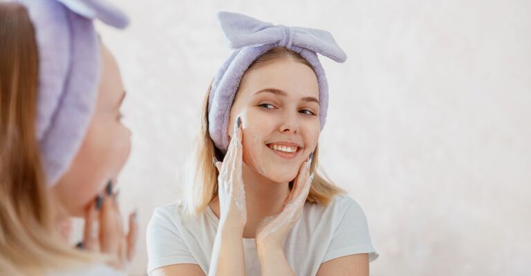 ragazza fa skin care davanti allo specchio