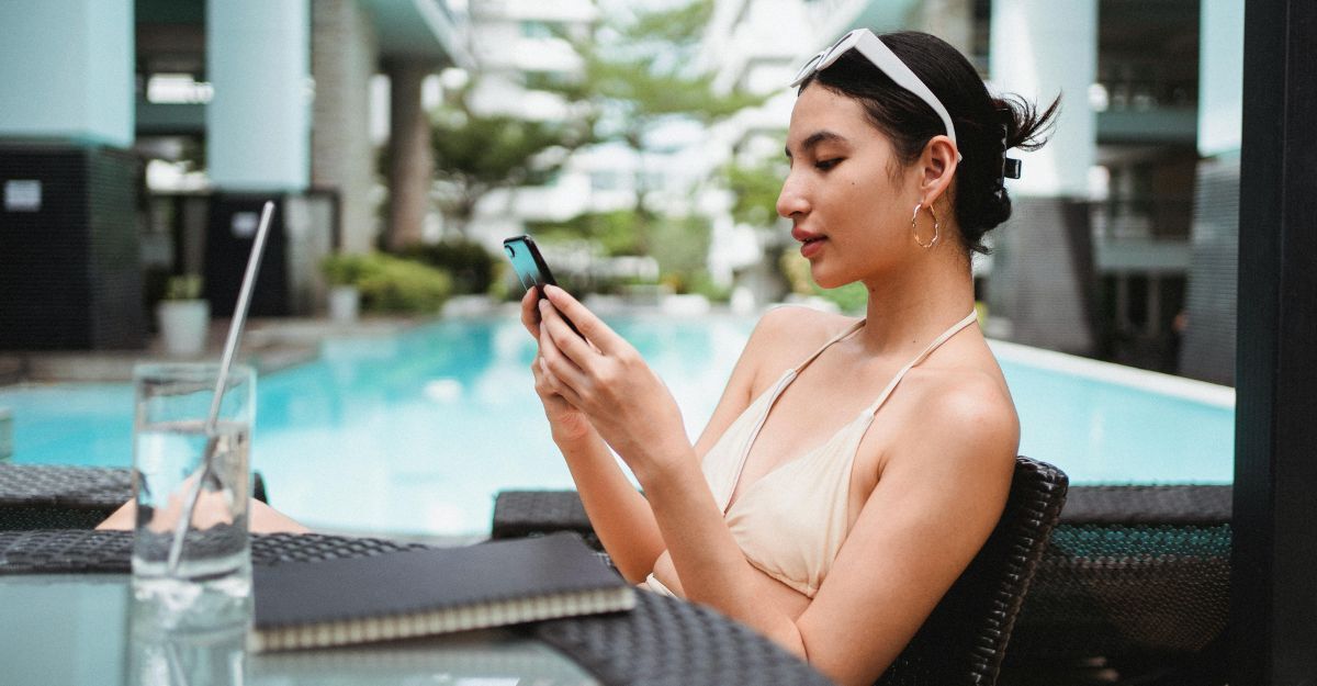 Ragazza in costume usa lo smartphone