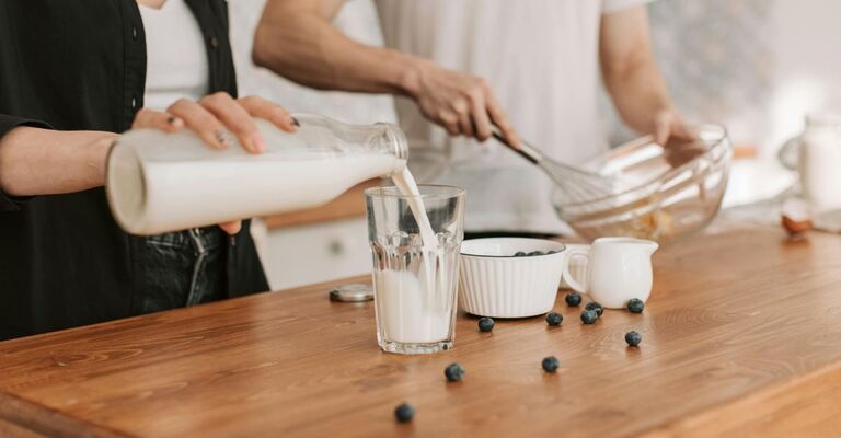 Una persona versa il latte nel bicchiere mentre prepara un dolce con il partner