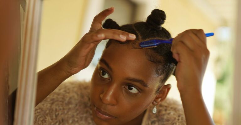 Ragazza si sistema i baby hair con un pettinino